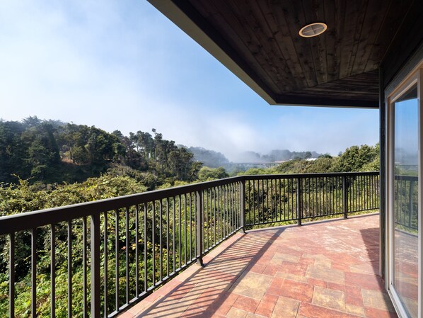 A balcony with a view of a forested landscape and a bridge in the distance. - Holiday Inn Express Ft Bragg by IHG (Fort Bragg)