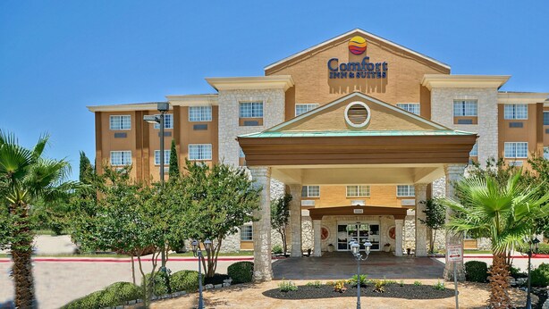 Un hotel Comfort Inn & Suites con fachada de piedra, múltiples ventanas y un acceso cubierto.