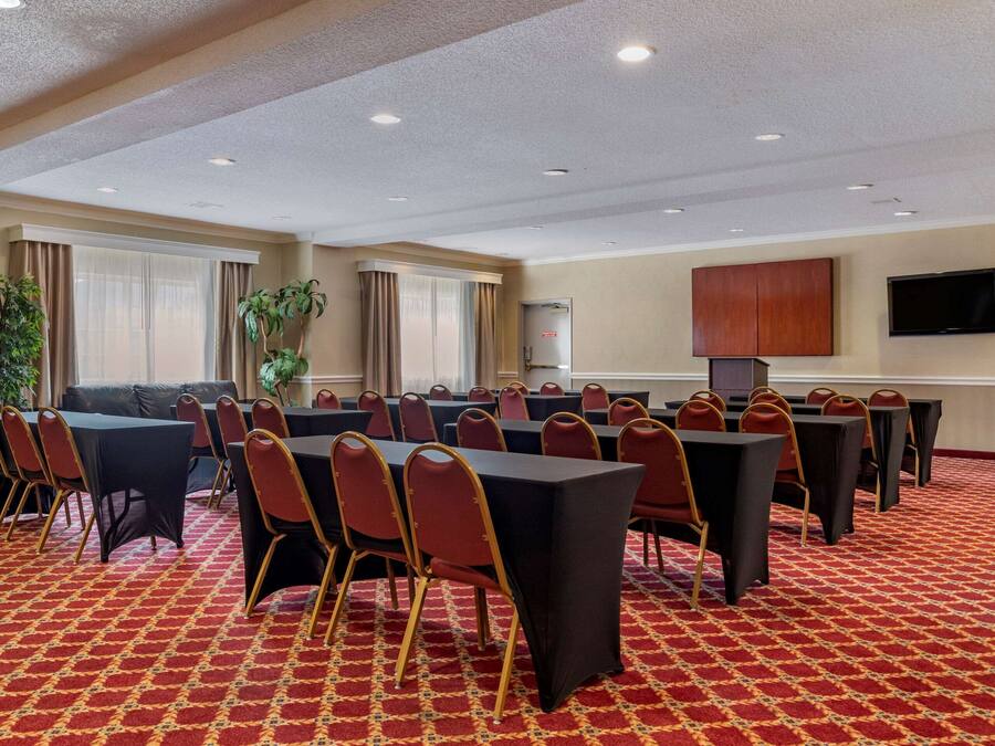 A conference room with tables and chairs, a television, and an American flag.
