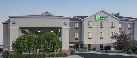 A Holiday Inn Express building with a covered entrance and a brick facade.