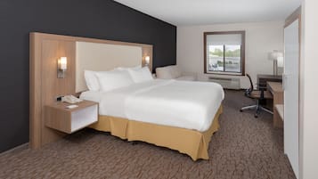 A hotel room with a large bed, bedside tables, a desk, and a chair.