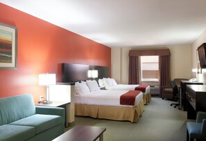 Een hotelkamer met twee bedden, een bureau, een stoel, een televisie en een schilderij aan de muur.