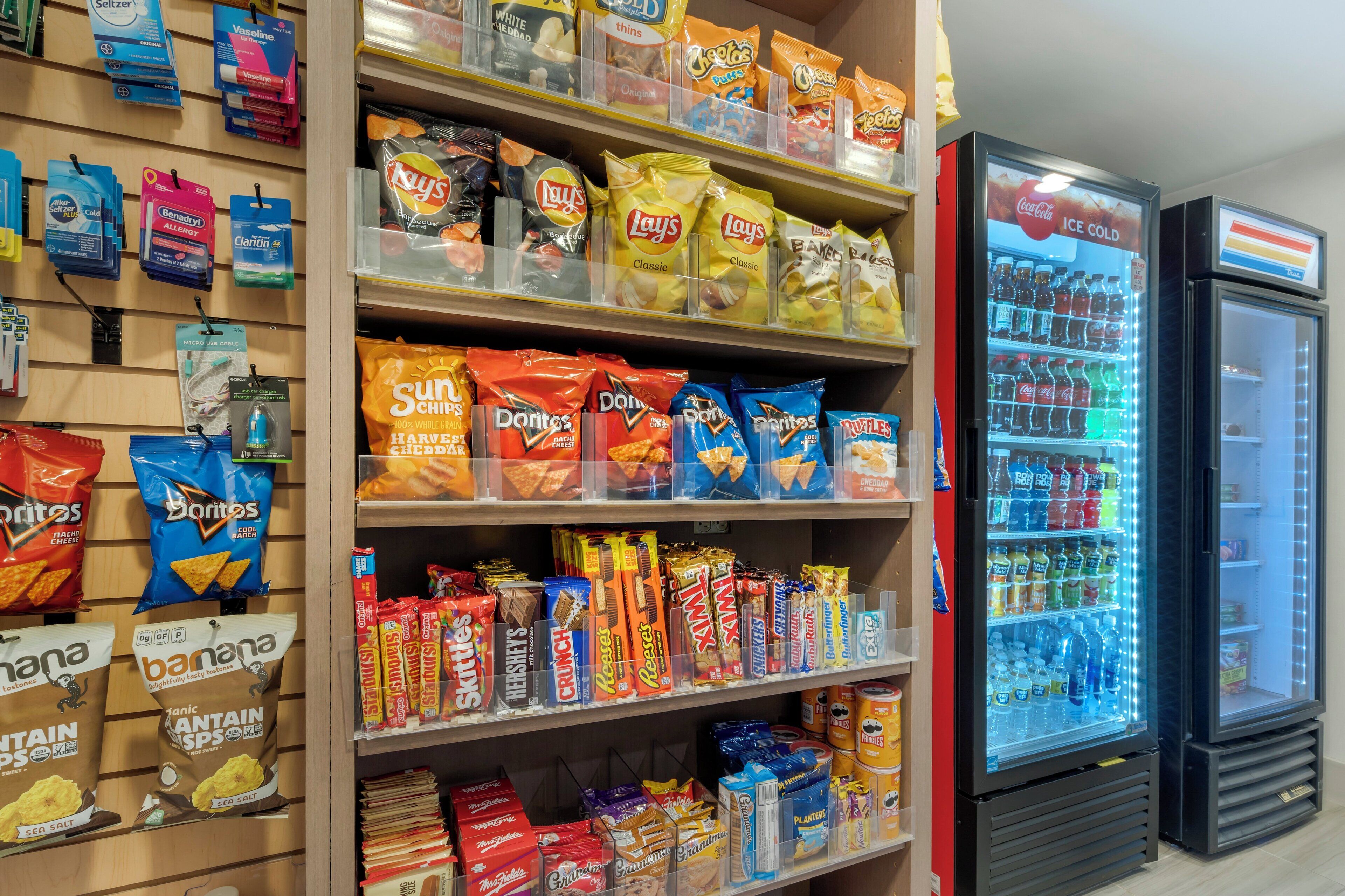 A snack aisle with various chips and snacks, including Doritos, Lay's, and Pringles.