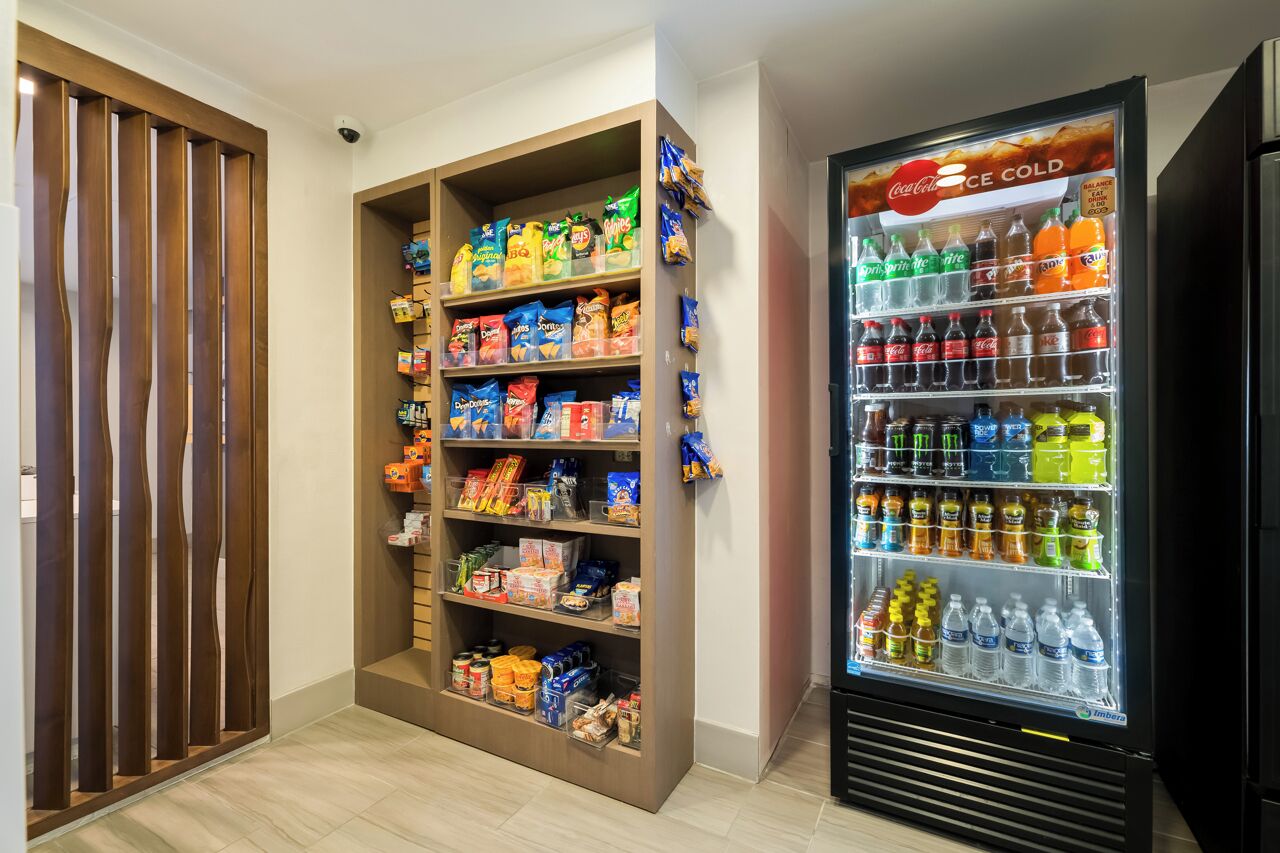 A vending machine stocked with snacks and beverages, and a shelf with packaged goods.