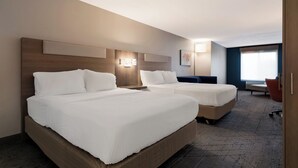 A hotel room with two beds, a wooden headboard, a wall-mounted light, and a window with blinds. - Holiday Inn Express Hotel & Suites The Villages by IHG (Lady Lake)
