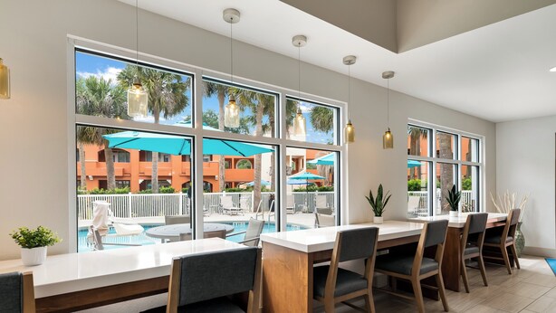 A modern dining area with a pool view, large windows, and a clean, contemporary design. - Holiday Inn Express Hotel & Suites The Villages by IHG (Lady Lake)