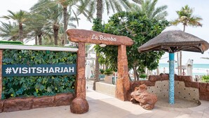 A sign reading "La Bamba" with a hashtag "#VISITSHARJAH" and a tropical garden backdrop. - Occidental Sharjah Grand (Sharjah)