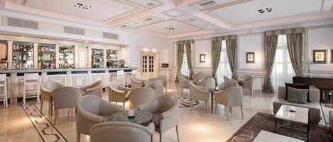 A hotel lobby with a bar, seating area, and a fireplace.