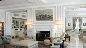 Un amplio vestíbulo de hotel con chimenea, asientos cómodos y zona de comedor.