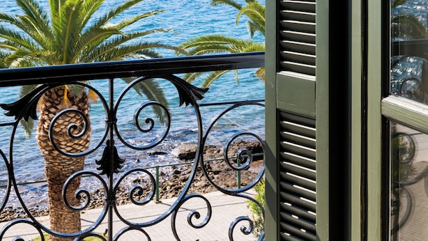 Un balcón con vista al mar y a las montañas.
