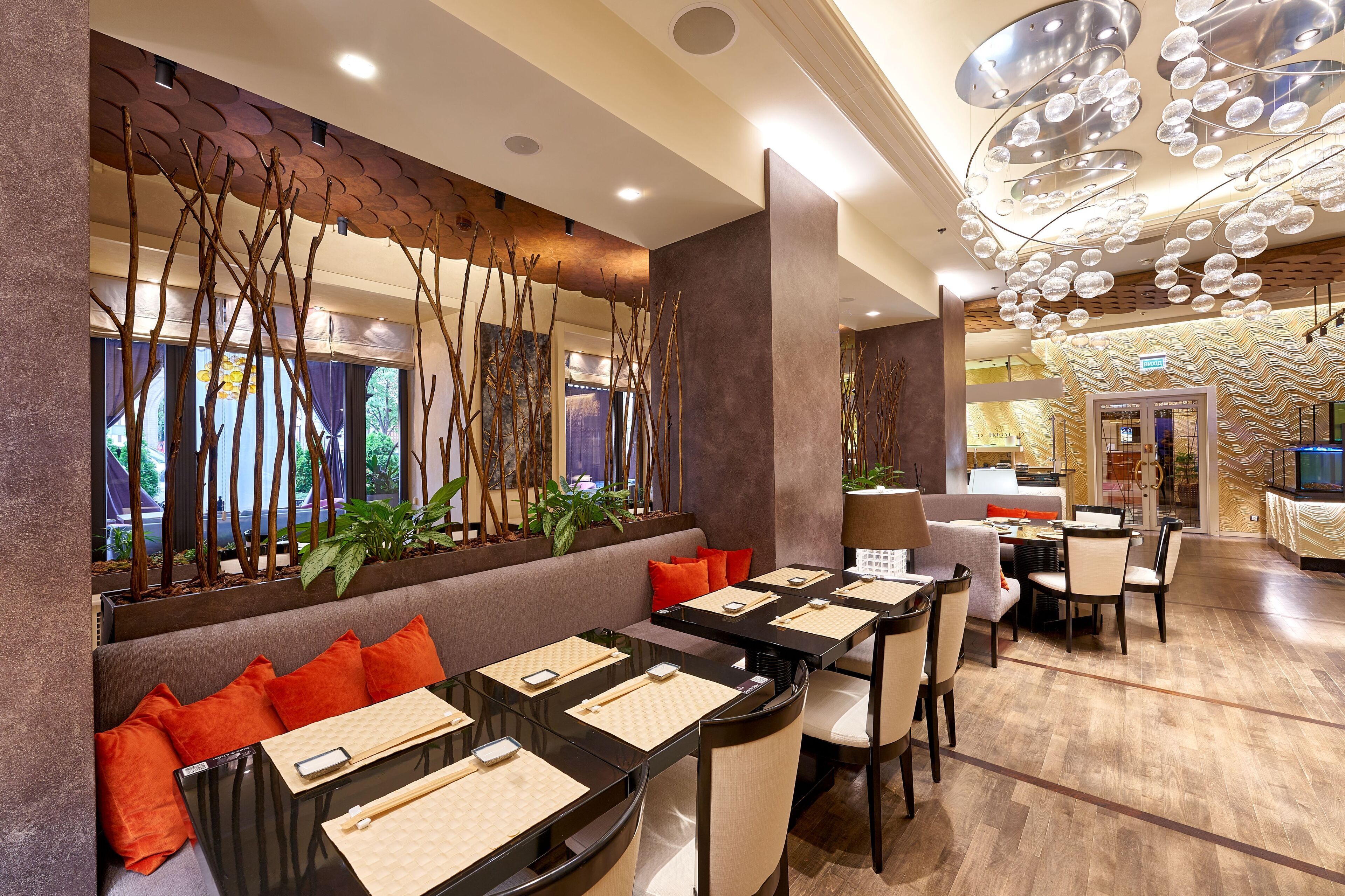 Un restaurant moderne doté d’une longue table conviviale, de sièges confortables et d’un mur décoratif agrémenté d’éléments verticaux.