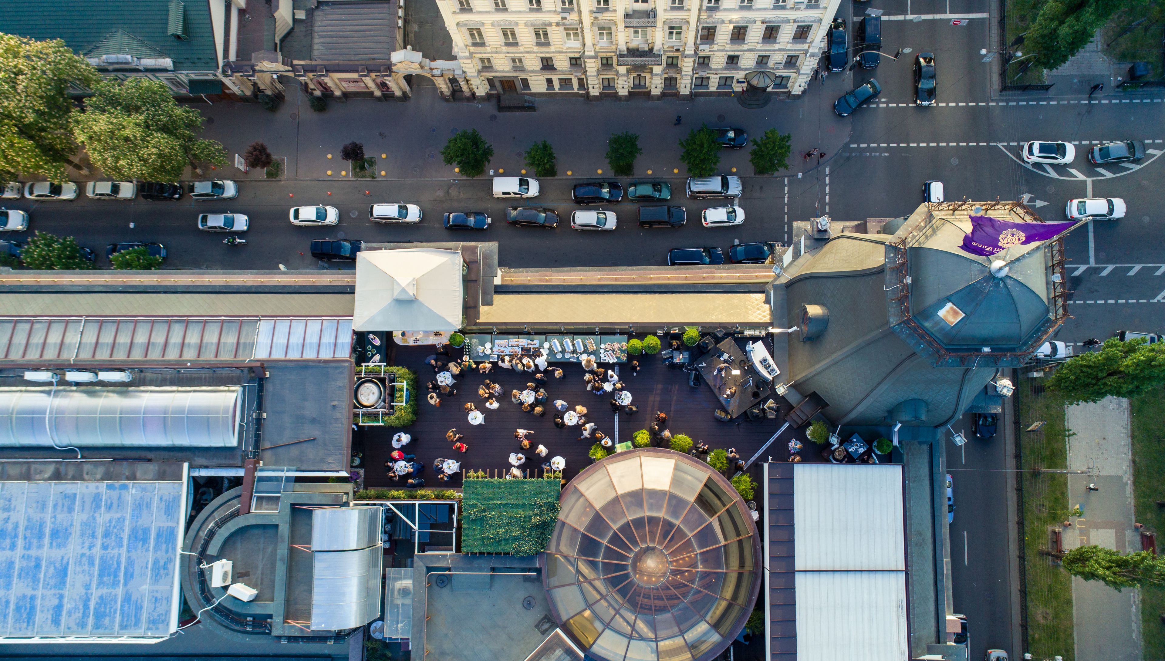 An aerial view of a building with a rooftop terrace, a large circular skylight, and a dome structure.