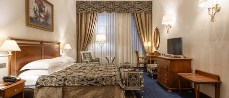 Una habitación de hotel con una cama grande, un escritorio con lámpara, televisión y cómoda.