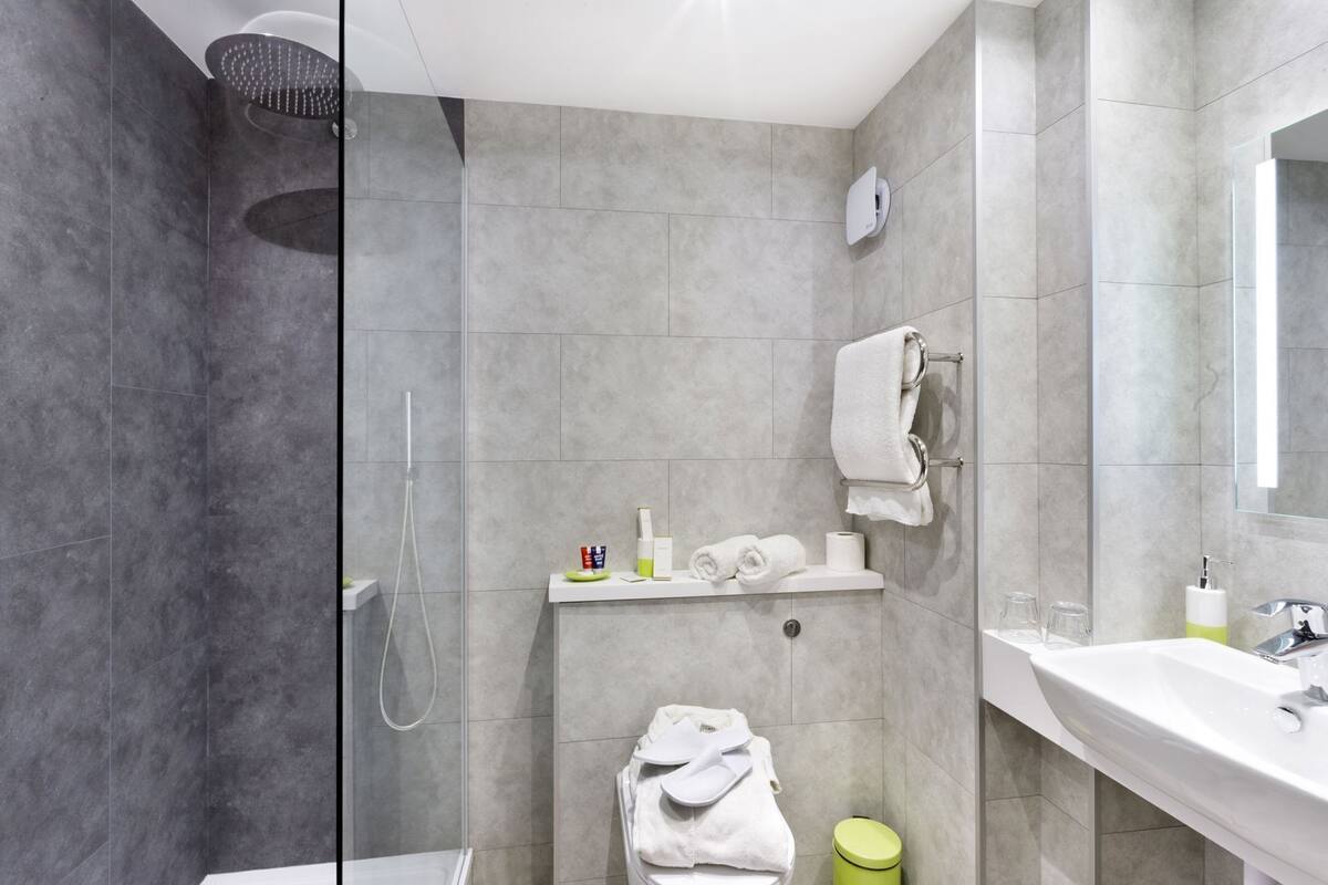 Un baño moderno con ducha, inodoro y lavamanos.