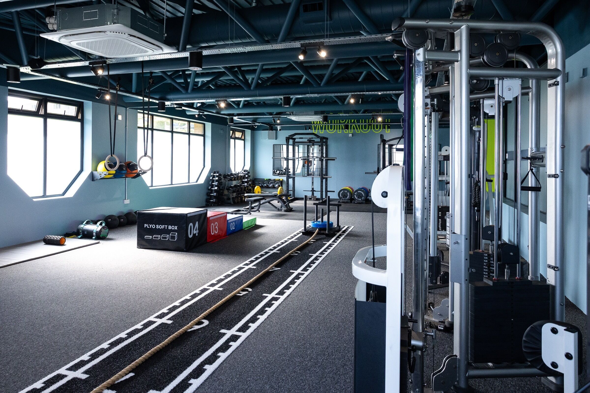 A gym with exercise equipment, a plyo soft box, and a weight rack.