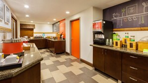 Cozinha moderna com bancadas de granito, máquina de café e dispensador de suco.
