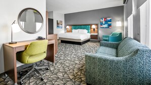 A hotel room with a bed, desk, chair, and a couch. - Hampton Inn Bloomington West (Bloomington)