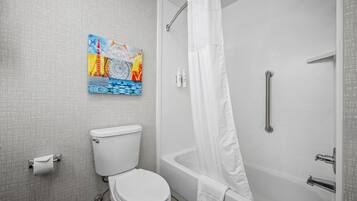 A bathroom with a toilet, a bathtub, and a shower curtain.