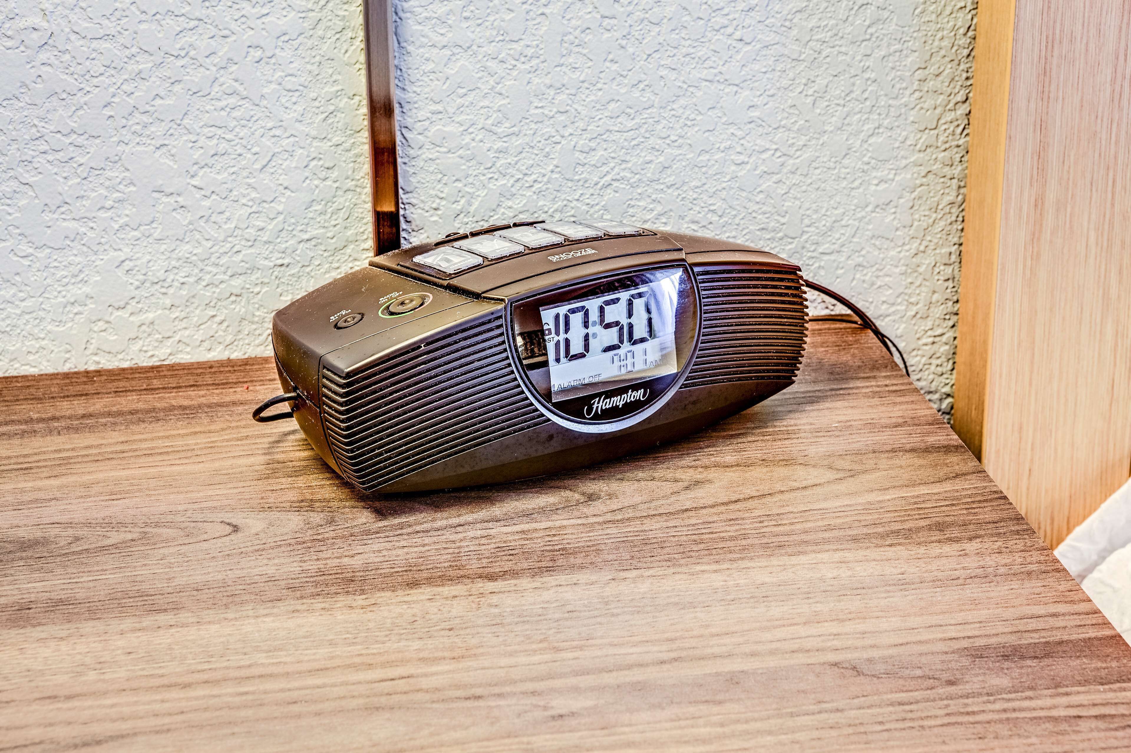 A digital clock radio on a wooden surface.