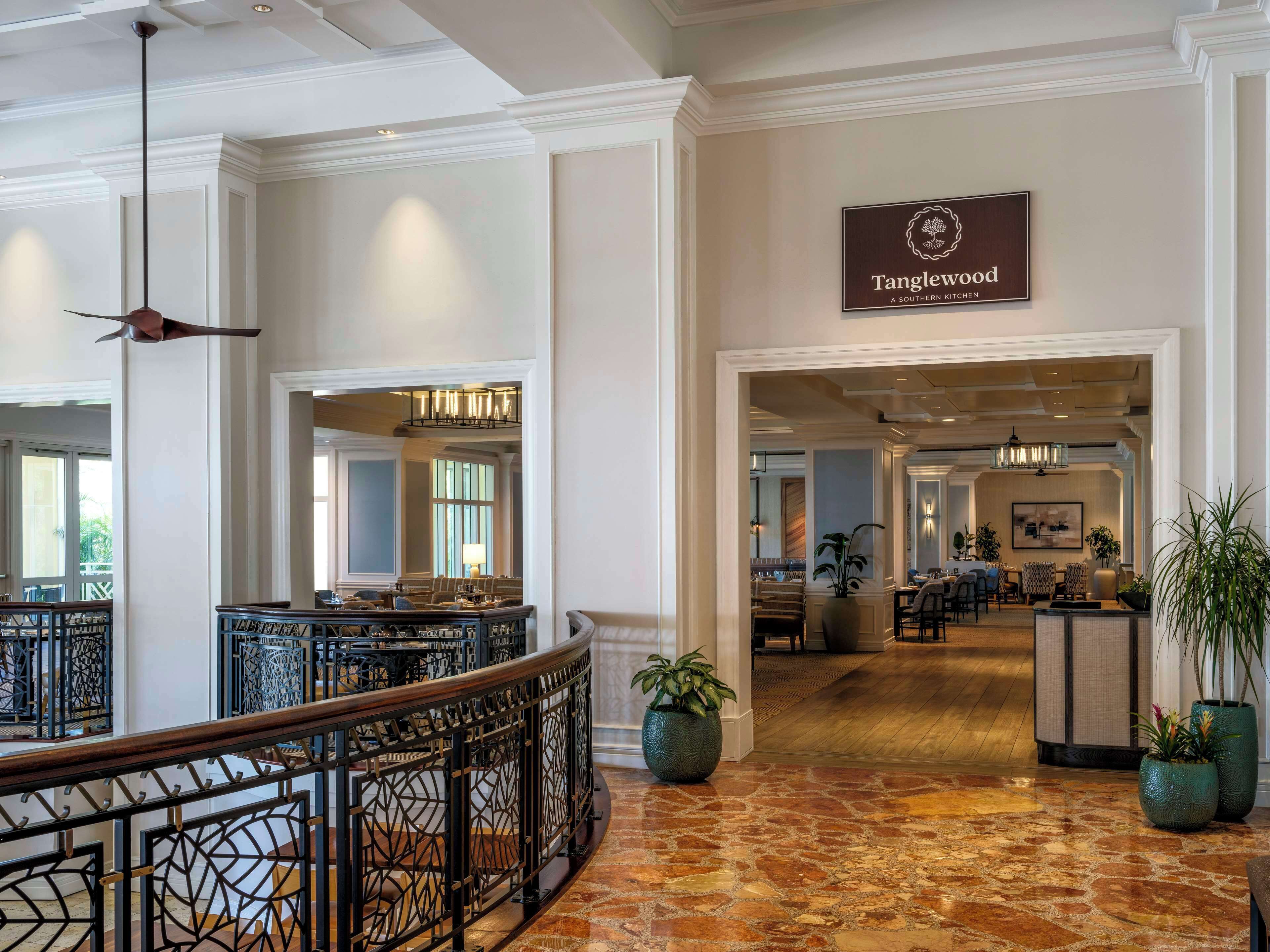 A lobby with a sign for 'Tanglewood', a dining area, and a reception desk.