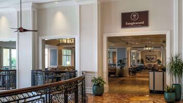 A lobby with a sign for 'Tanglewood', a dining area, and a reception desk.