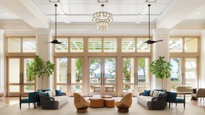 A spacious lobby with large windows, modern furniture, and a chandelier. - Hyatt Regency Coconut Point Resort & Spa (Bonita Springs)