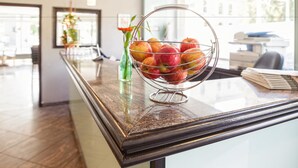 A reception area with a marble counter, a metal fruit bowl, and a vase with flowers. - Hotel Berlin Mitte by Coffee Fellows (Berlin)
