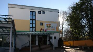A hotel building with a modern design, featuring a staircase leading to the entrance, a glass facade, and a sign indicating it is a hotel in Stadt Pasing.
