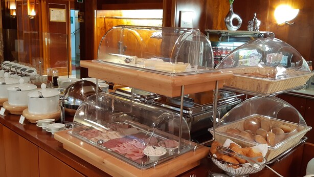 A buffet with various food items and utensils, including bowls, plates, and baskets. - Hotel Stadt Pasing (Munich)