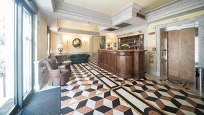 A lobby with a check-in counter, seating area, and an elevator. - Hotel Donatello (Rome)