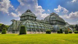 A large greenhouse with multiple domes and a glass structure, surrounded by well-manicured lawns and trees. - Arthotel ANA Gala, Trademark Collection by Wyndham (Vienna)