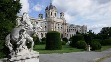 Ein klassizistisches Gebäude mit einer großen Kuppel und Statuen im Vordergrund.