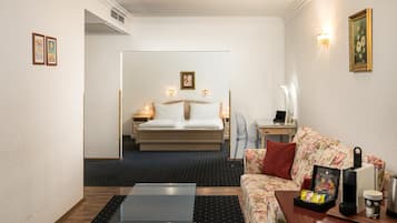 Ett hotellrum med en säng, ett skrivbord, en soffa och en kaffemaskin.