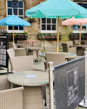 Outdoor wicker furniture, a sign for The Rutland Arms, and a menu board. - The Rutland Arms Hotel, Bakewell, Derbyshire (Bakewell)