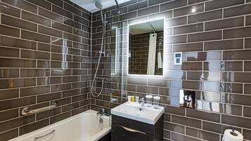 A modern bathroom with a bathtub, a vanity with a mirror, and a shower area.