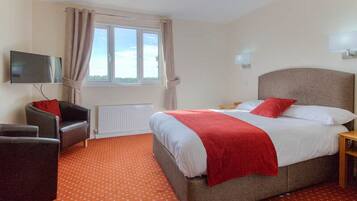 Relax in this inviting space with a large bed, TV, and cozy seating area.