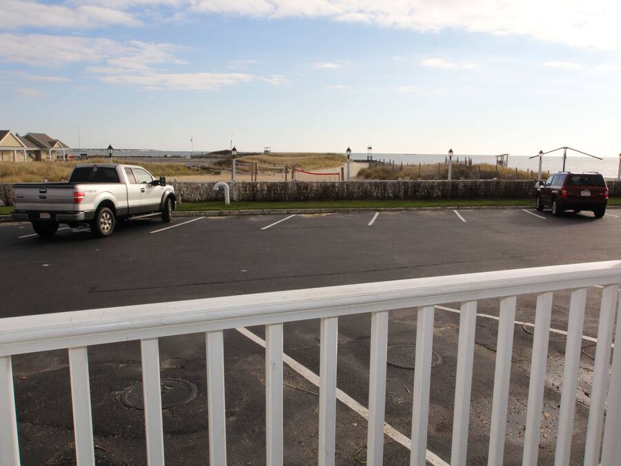 A parking lot with a white pick-up truck and a maroon SUV.