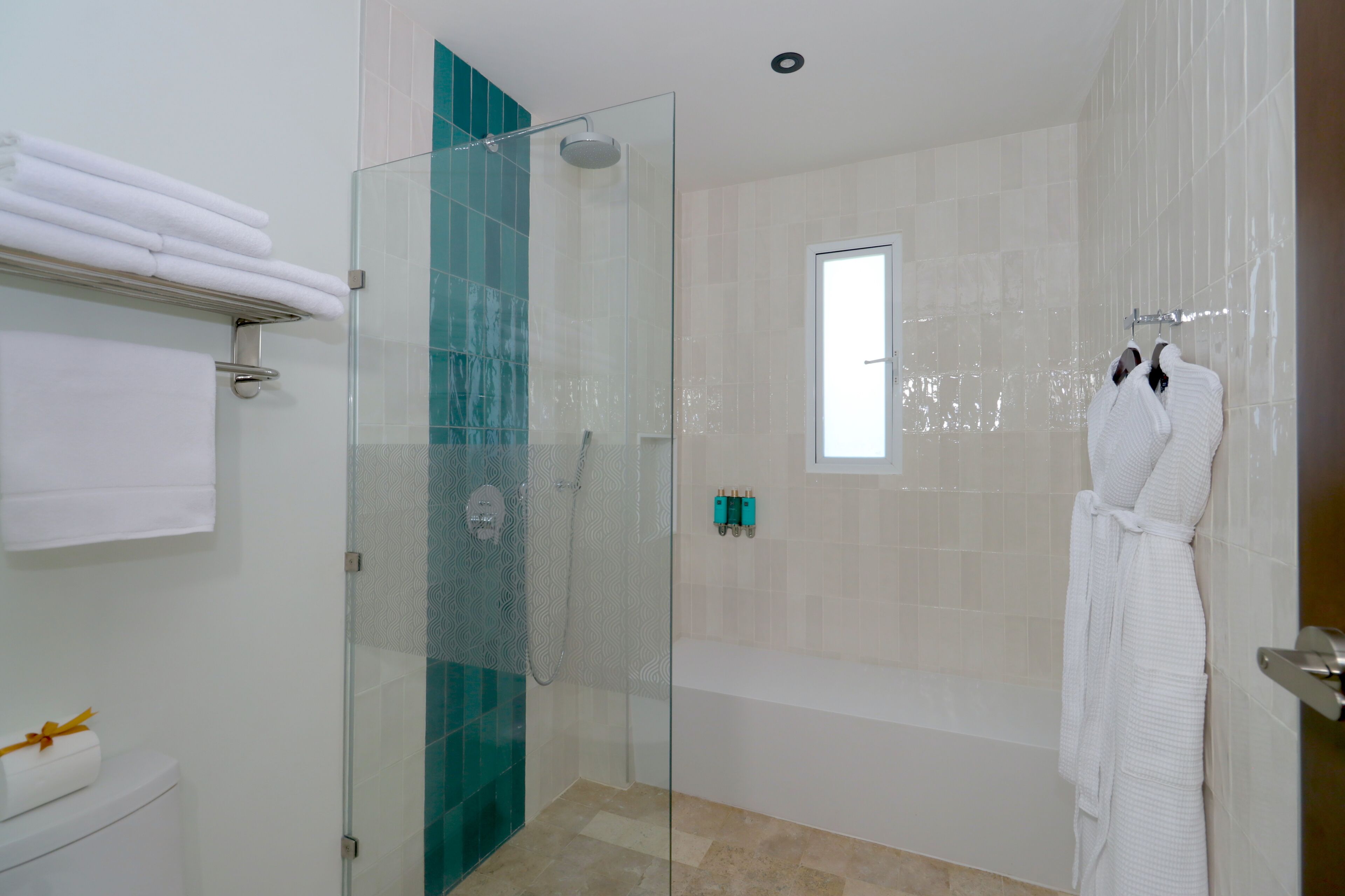 Un baño moderno con ducha envuelta en vidrio, una bañera y una toalla blanca para la bañera.