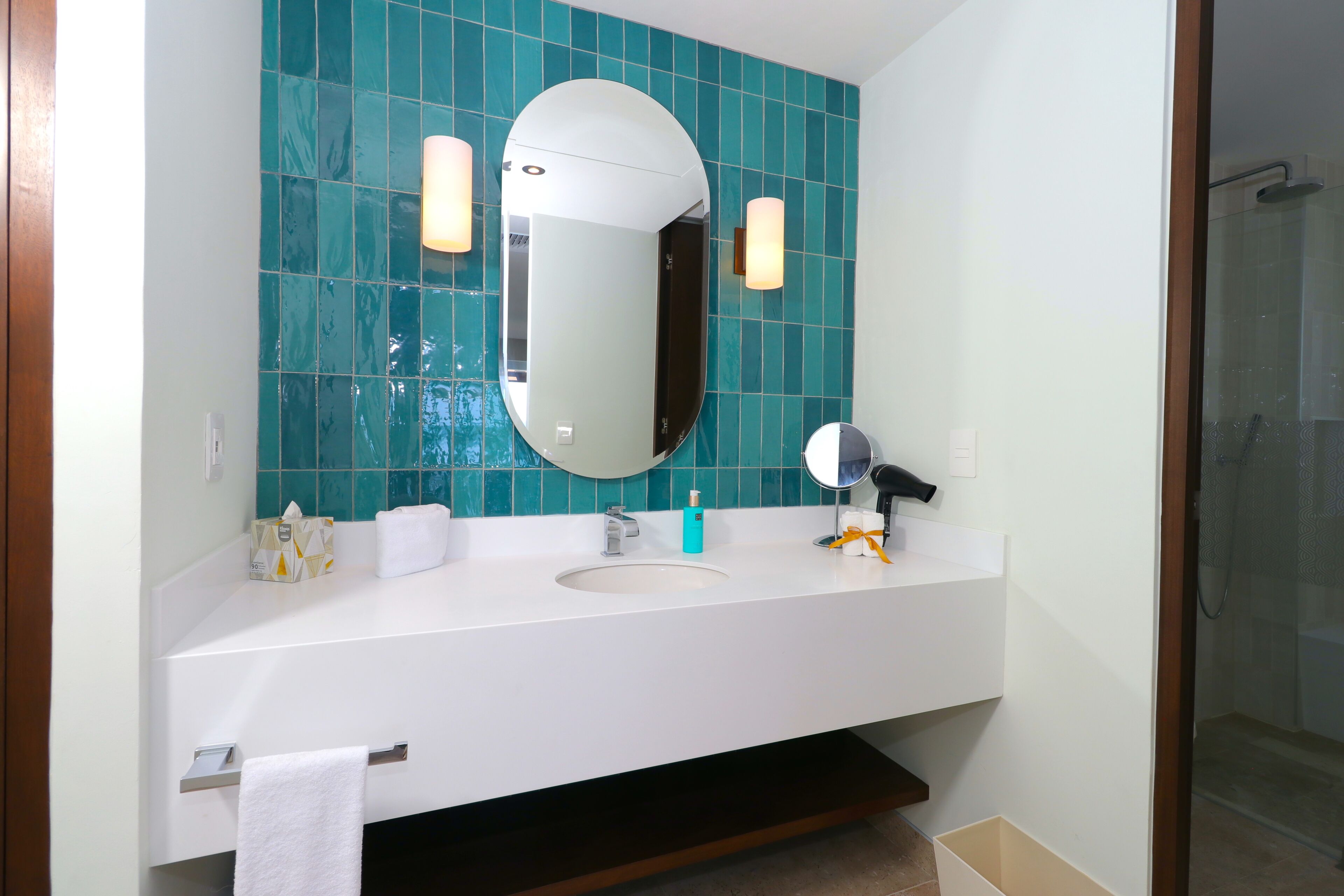 A bathroom with a white sink, a mirror, and a shower.