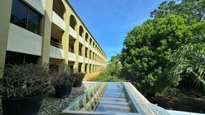 A building with multiple balconies and a glass water feature in the foreground. - Hotel Casa Colonial Cozumel (Cozumel)