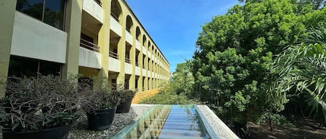 A building with multiple balconies and a glass water feature in the foreground.