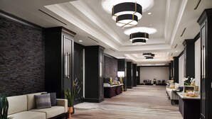 A modern hotel lobby with a sofa, plants, a reception desk, and a patterned carpet. - Austin Marriott South (Austin)