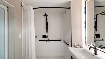 A modern bathroom with a shower, a sink, and a mirror.