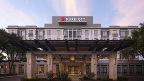 A Marriott hotel with a modern facade, a covered entrance, and a landscaped front garden. - Austin Marriott South (Austin)