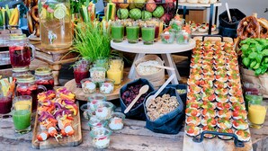 A variety of food and drink options including fruits, juices, and snacks on a wooden table. - Welcome Hotel Wesel (Wesel)
