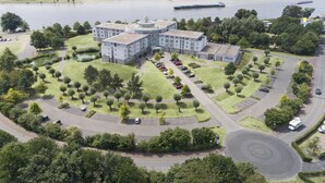 An aerial view of a hotel with a central courtyard, surrounded by trees and a parking area. - Welcome Hotel Wesel (Wesel)