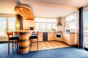 A modern kitchen with a central island, bar stools, a built-in oven, and a large window offering a view.