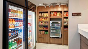 A grocery store with refrigerated beverage coolers, snack shelves, and a refrigerated section.