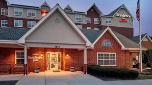 A Marriott Residence Inn with a brick facade, numbered 1610, and a flagpole with an American flag.