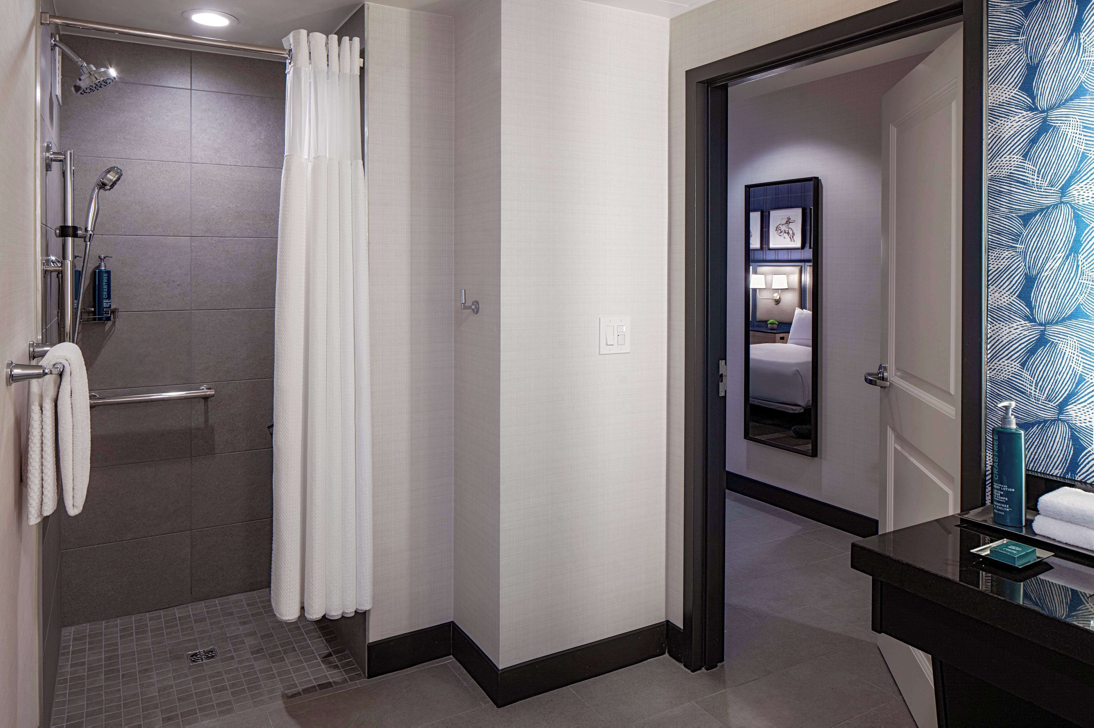 Un baño de hotel con ducha, inodoro y lavamanos.